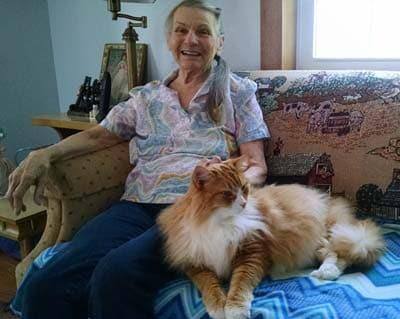 Rose and her cat Fluffy sitting on a couch together.